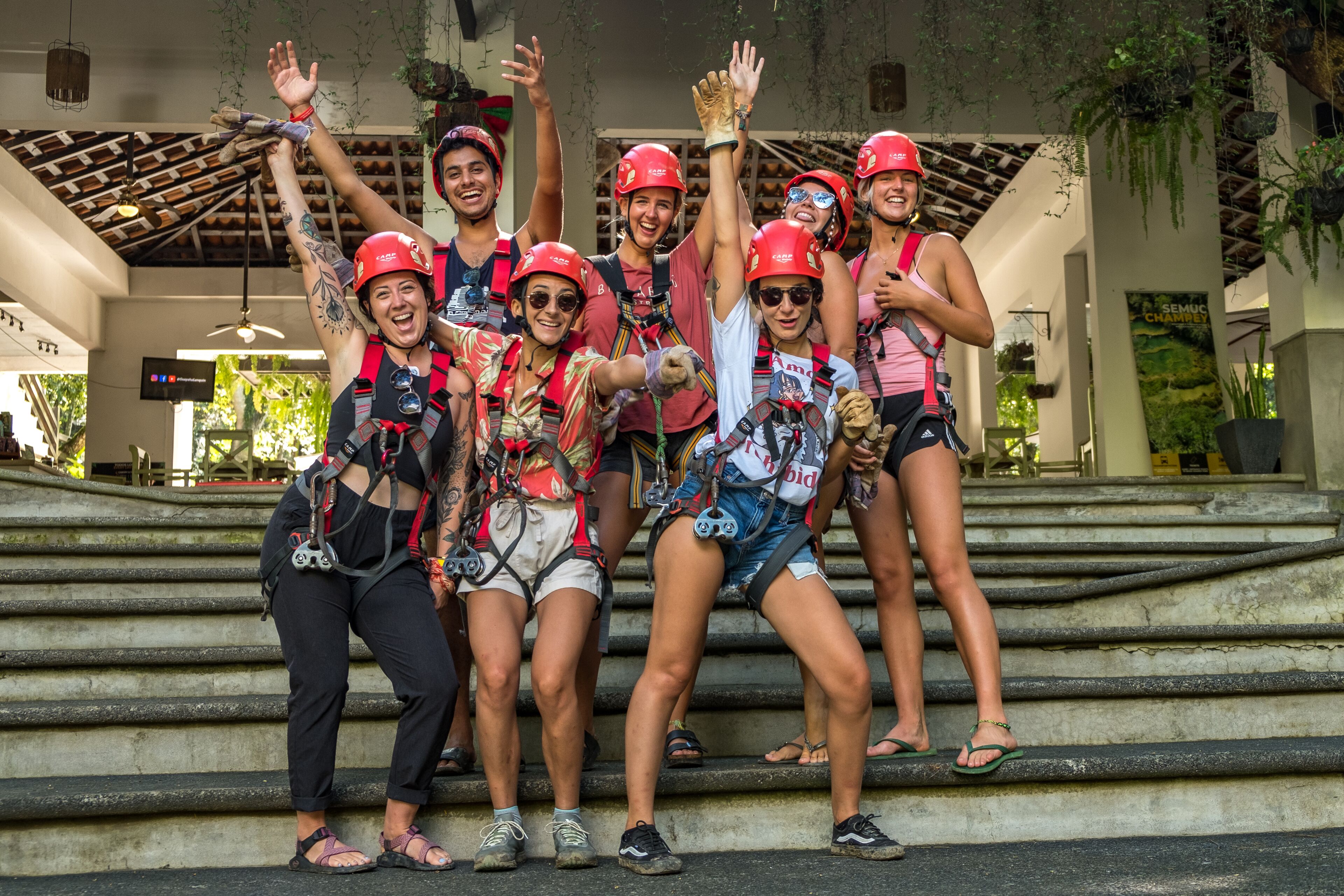 A group of people on outdoor steps, wearing helmets and harnesses, suggesting an adventure activity.
