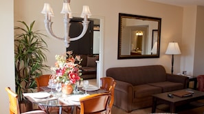 Relax in this stylish living room with a dining area, featuring a sofa, coffee table, and dining table for four.