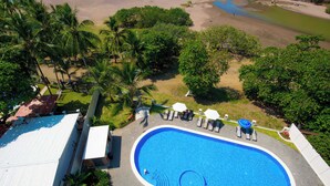 Una piscina circondata da palme e da una spiaggia.