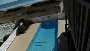 Piscina com vista para a praia e oceano.