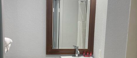 Un baño con inodoro, lavabo y espejo.