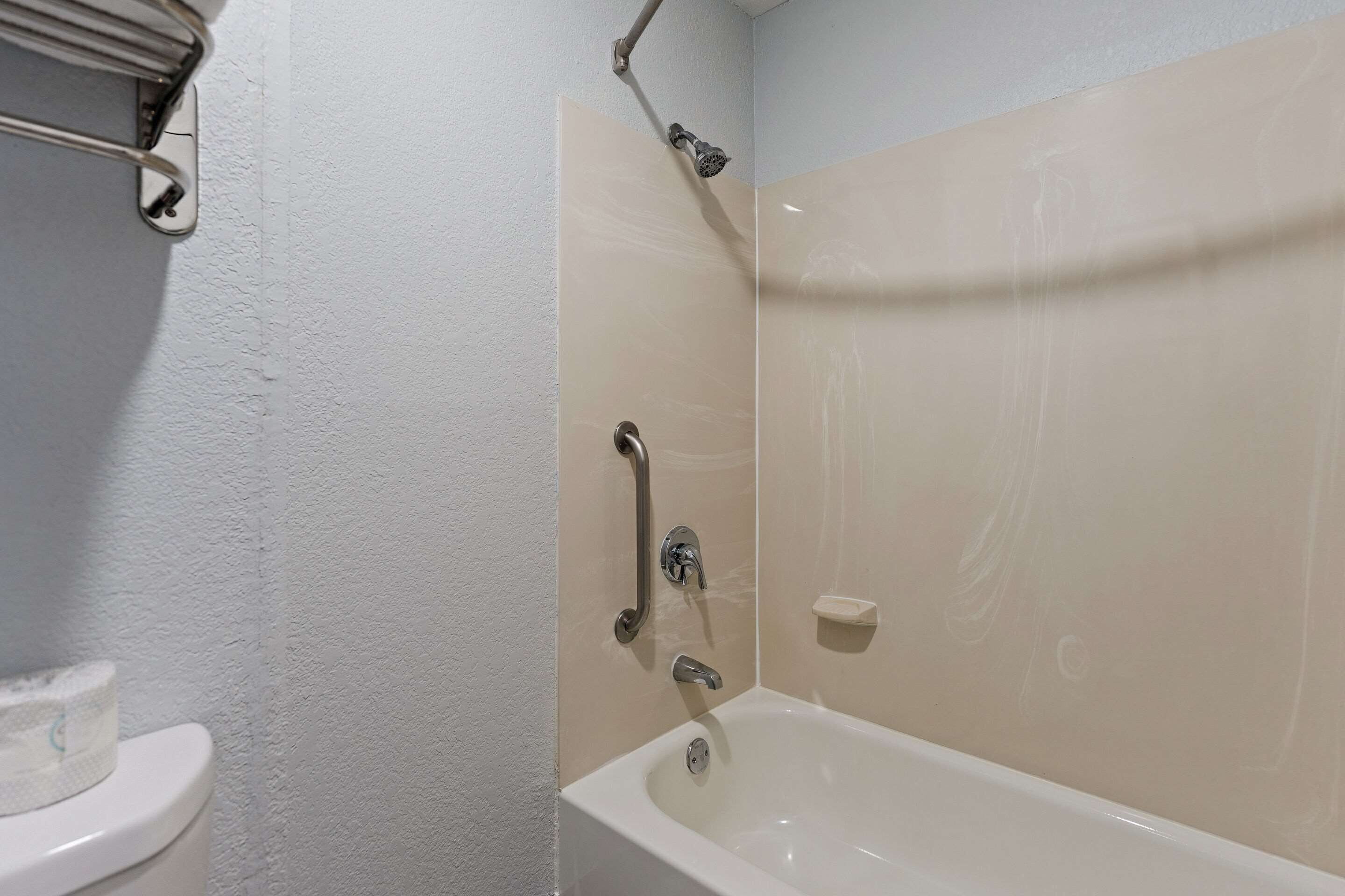 A bathroom with a bathtub, a toilet, and a shower.