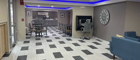 A hotel lobby with a checkered floor, a reception desk, a clock, and a blue sofa.