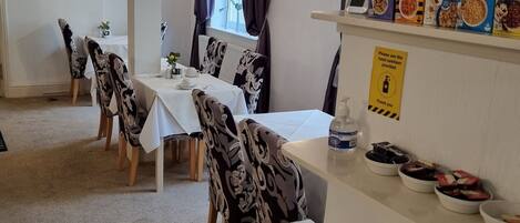 En matplats med bord och stolar, en buffé med olika maträtter samt information om matallergier och överkänsligheter.
