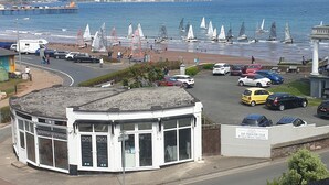A coastal area with a marina, a white building labeled 'The Paignton Club', and a road with parked cars. - The Sands Hotel (Paignton)