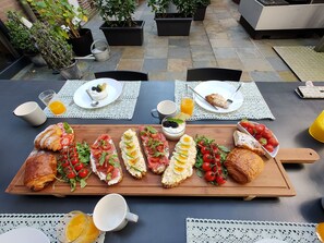 Un bufé de desayuno con diversos platos y bebidas sobre una mesa.
