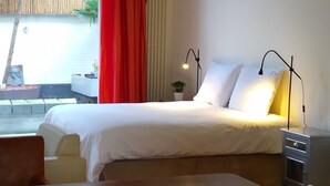 A hotel room with a bed, bedside table, lamp, and a view of the outside. - B&B Hart van Leiden (Leiden)