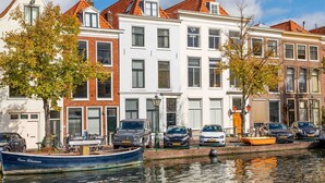 A row of traditional European townhouses with a canal in the foreground. - B&B Hart van Leiden (Leiden)
