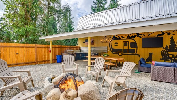An outdoor patio with Adirondack chairs, a fire pit, and a covered seating area with a mural. - Country Getaway near Seattle (Maple Valley)