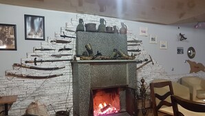A room with a fireplace, a brick wall, and various decorative items. - Green flower is located in the historical part of Kutaisi.5-minute walk  centre. (Kutaisi)