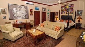 Een stijlvol ingerichte slaapkamer met een hemelbed, een bank, een bureau en een stoel.