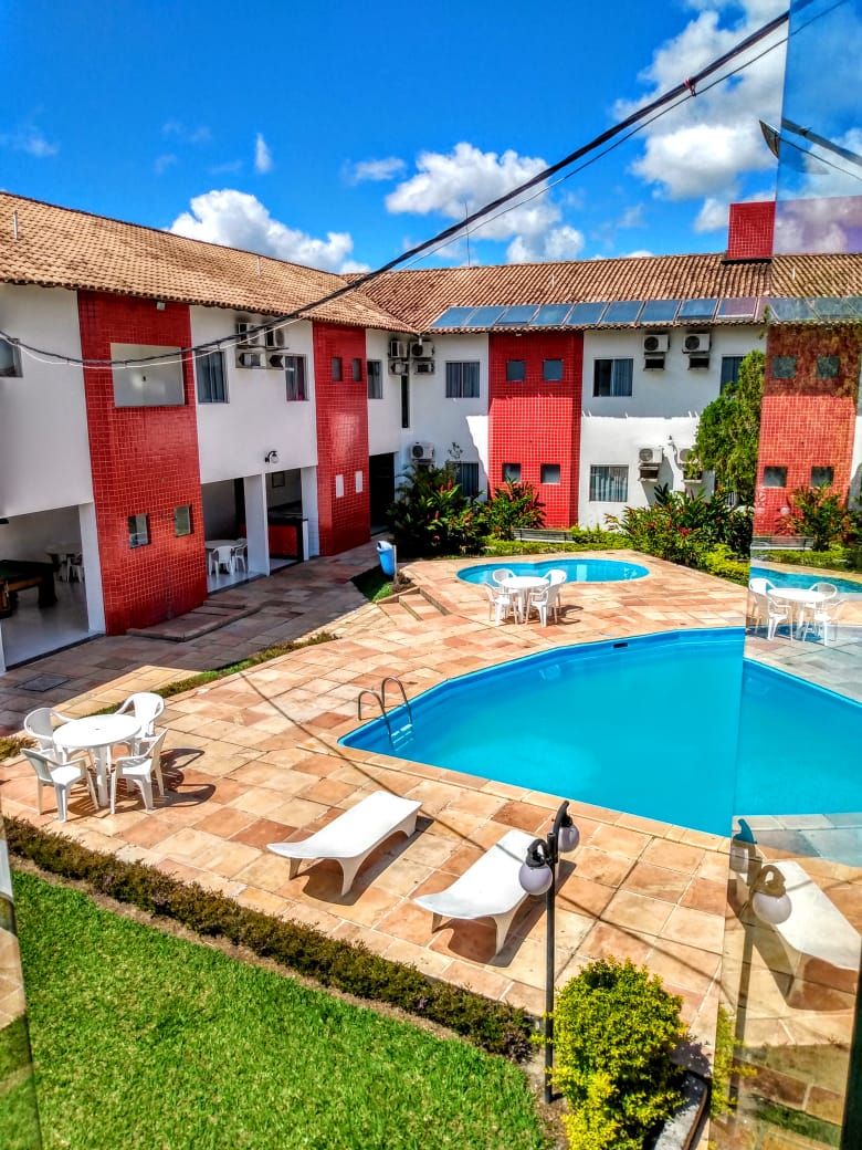 A courtyard with a swimming pool, outdoor seating, and a building with red and white walls.