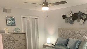 A bedroom with a bed, dresser, nightstand, and decorative wall art.