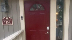 A red door with a 'Welcome' mat, a mailbox, and a 'Beachwalk 106' sign on the wall. - Beachwalk 106 Shipyard Hilton Head Island, 5 Min. Walk to Beach (Hilton Head Island)
