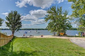 A lakeside view with boats, a wooden fence, and a grassy area. - Sunsets await you! Boat Mooring! Game room for everyone to have fun!  (Raymond)