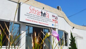 A building with a sign that reads "Sitraefa" and mentions "Colonia de Férias / Rede Conveniada". - Colonia de Férias Sitraemfa (Peruíbe)
