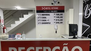 Mostrador de recepción de hotel con un cartel que muestra las tarifas de las habitaciones.