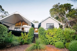 A modern house with a unique architectural design, featuring a large overhanging roof and a well-maintained garden.