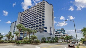 A hotel with a checkered facade, palm trees, and a clear blue sky. - OceanFront Condo with Dolphin Views - 2bd/2ba Myrtle Beach 11801 (Myrtle Beach)