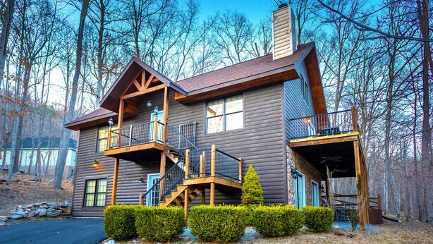 A log cabin with a balcony, a staircase, and a chimney. - Blue Pine Lodge  - w/ Hot Tub - What a Mountain Cabin Should Be! (McGaheysville)