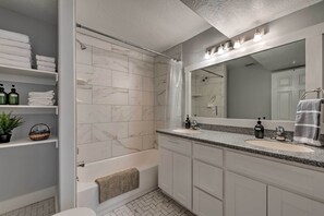 Bañera con ducha, secador de pelo, toallas, shampoo
