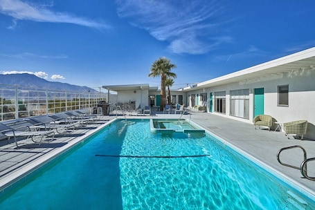 Una piscina al aire libre, sillones reclinables de piscina