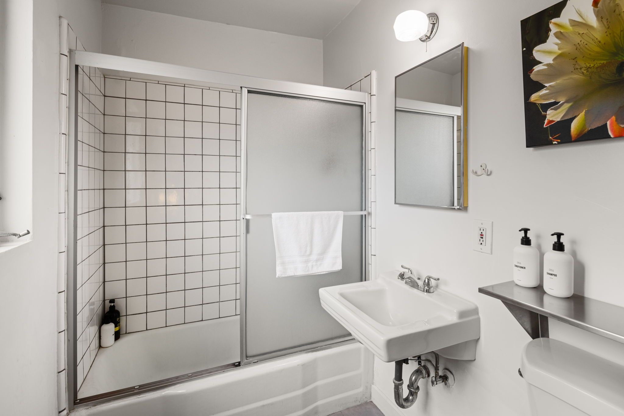 Une salle de bain moderne avec une douche, un lavabo et un miroir.