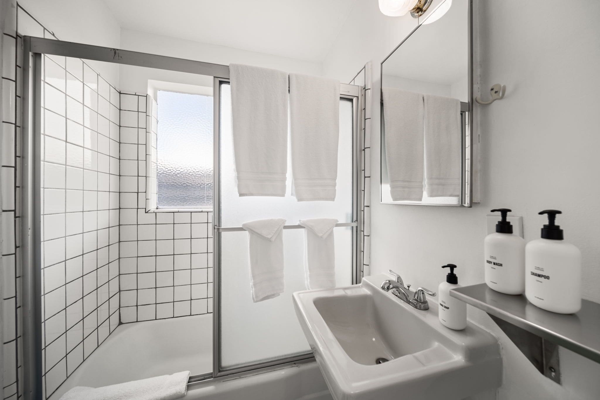 Ein modernes Badezimmer mit Dusche, Waschbecken und Spiegel.