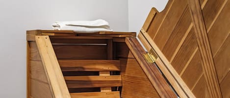 A wooden staircase with a built-in bench and a framed artwork on the wall.
