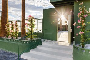 A staircase leading to a building entrance with a view of palm trees and a clear sky. - Sagewater Springs - Adult Only (Desert Hot Springs)
