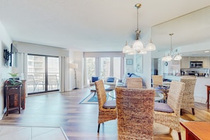 Relax in this spacious living area with a large dining table and comfortable wicker chairs.
