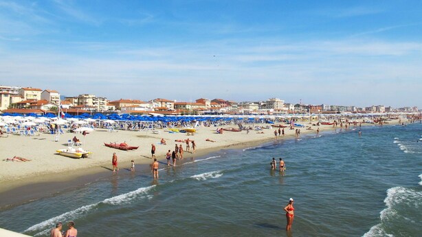 A beach with numerous umbrellas and sun loungers, a sandy shore, and a clear blue sky. - Beautiful apartment for 5 guests with A/C, TV and balcony (Camaiore)