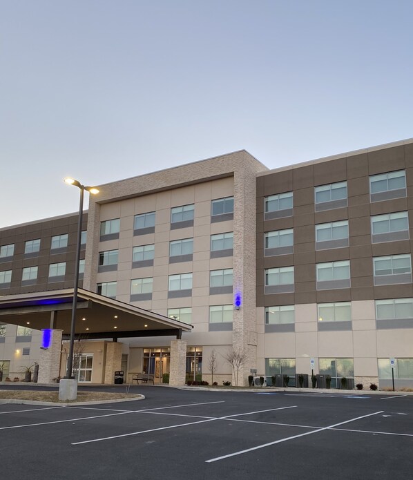 A multi-story hotel with a covered entrance, parking lot, and a clear sky. - Holiday Inn Express & Suites Staunton by IHG (Staunton)