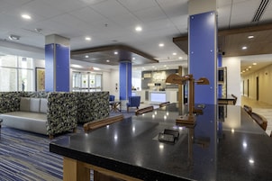 A modern lobby with a reception desk, seating area, and a view of the reception counter.