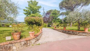 A pathway leading through a landscaped garden with various trees and potted plants. - Stunning private villa with private pool, WIFI, A/C, TV, terrace, pets allowed and panoramic view (Camaiore)