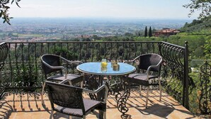 A terrace with a round table and four chairs, overlooking a scenic landscape. - Beautiful private villa with A/C, WIFI, hot tub, private pool, TV, patio and pets allowed (Montecatini Terme)