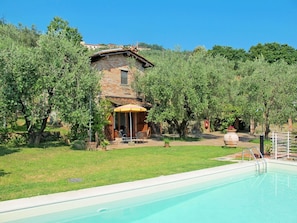 A poolside area with a stone building, outdoor seating, and a clear sky. - Private Villa with A/C, private pool, hot tub, internet, TV, patio, pets allowed, panoramic view (Montecatini Terme)