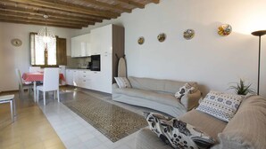 A modern kitchen with white cabinets, a dining table with chairs, a sofa with patterned cushions, and a decorative rug. - Private Villa with private pool, A/C, internet, hot tub, TV, patio, pets allowed, panoramic view (Montecatini Terme)