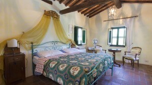 A bedroom with a bed, a nightstand, a chair, a table, and a fan. - Private Villa with private pool, A/C, internet, hot tub, TV, patio, pets allowed, panoramic view (Montecatini Terme)