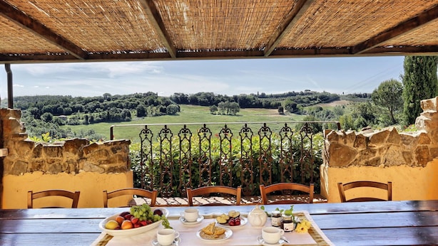 Una mesa lista para el desayuno con vistas a un paisaje rural.