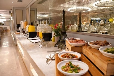 A buffet setup with various dishes, a decorative Eiffel Tower, and a modern interior.