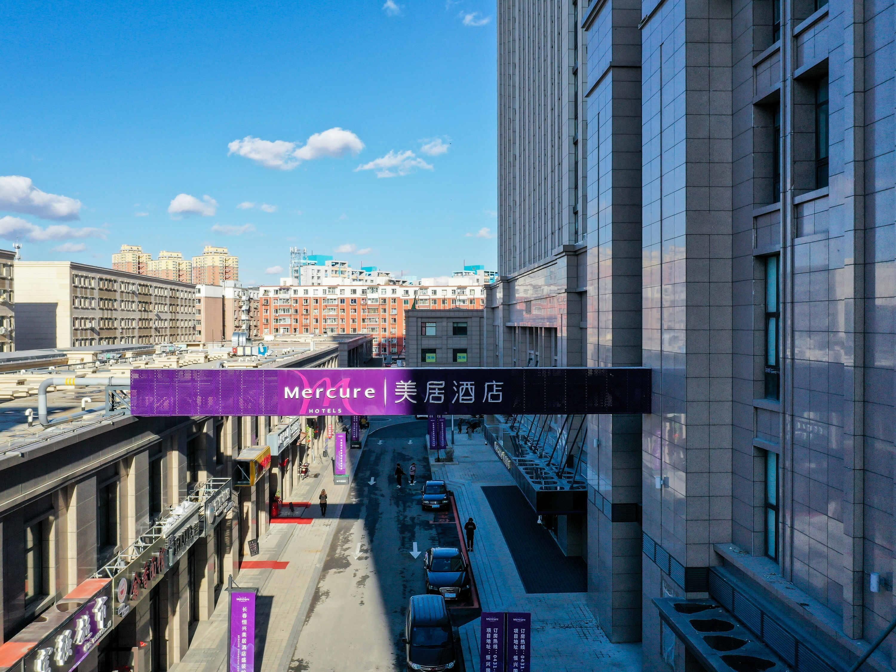 A Mercure hotel with a modern architectural style, located in an urban setting with a clear sky.