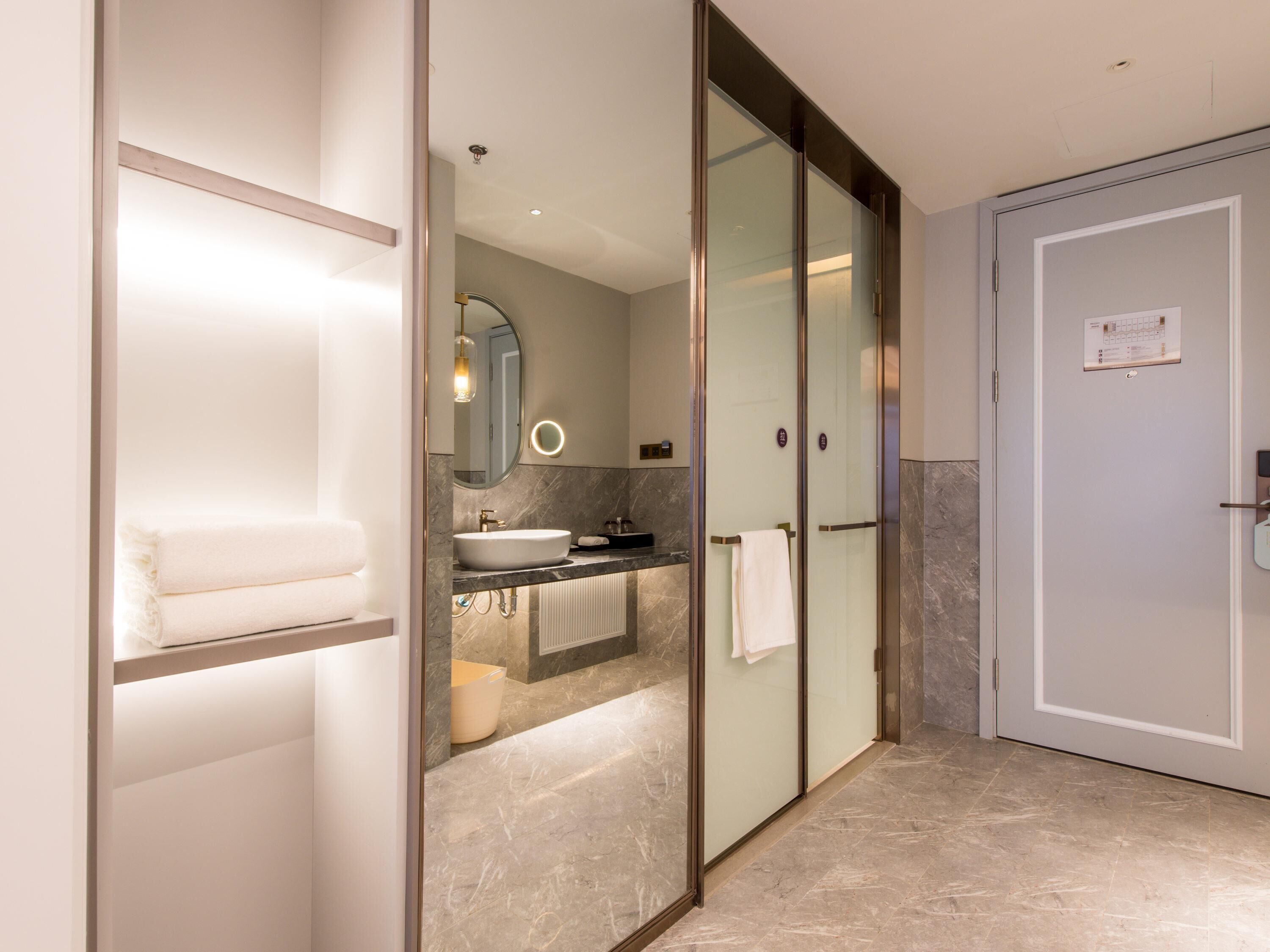 Une salle de bain moderne avec une douche à parois de verre, un lavabo et un porte-serviettes.
