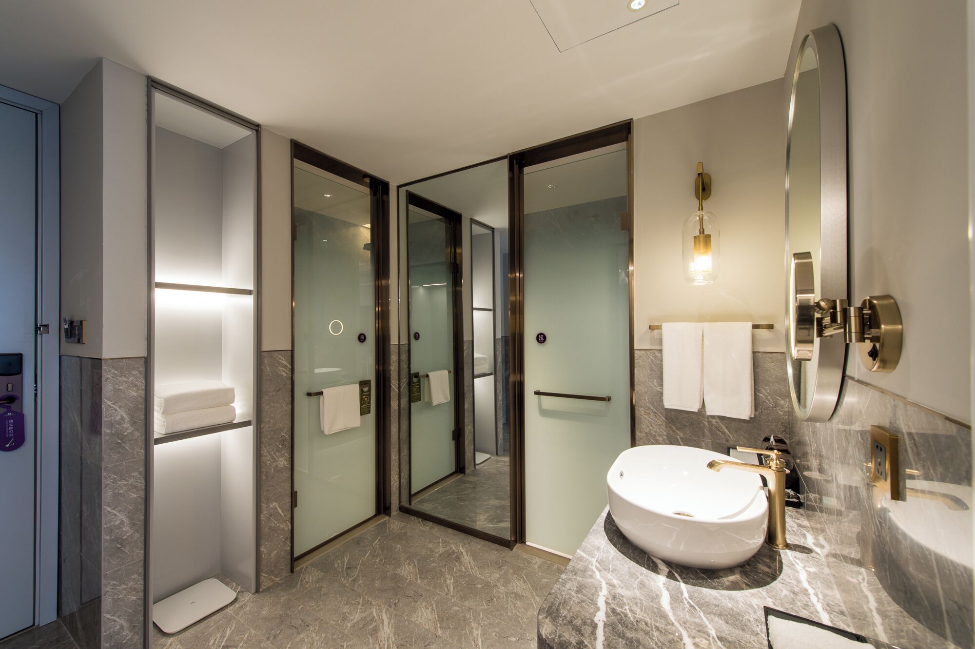 Un baño moderno con un espejo grande, un lavamanos y una zona de ducha.