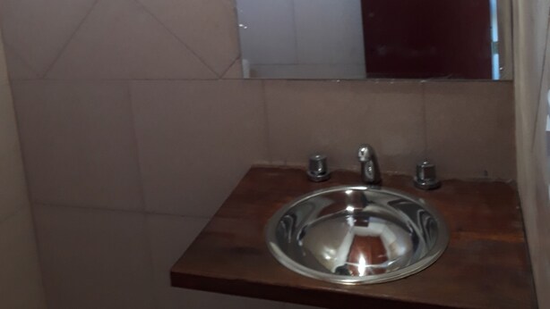 Ein Badezimmer mit Waschbecken, Spiegel und Fenster.