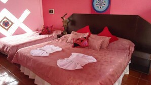 A hotel room with two beds, pink walls, and a decorative plate on the wall. - Cabañas & Apart Yki Shamuaika (Capilla del Monte)