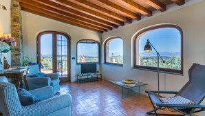 A spacious living area with a high ceiling, large arched windows, and a cozy seating arrangement. - Wonderful private villa for 5 guests with WIFI, private pool, TV, terrace and panoramic view (Impruneta)