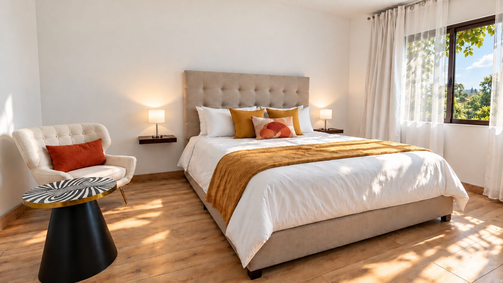 A bedroom with a bed, a chair, a side table, and a window with curtains.