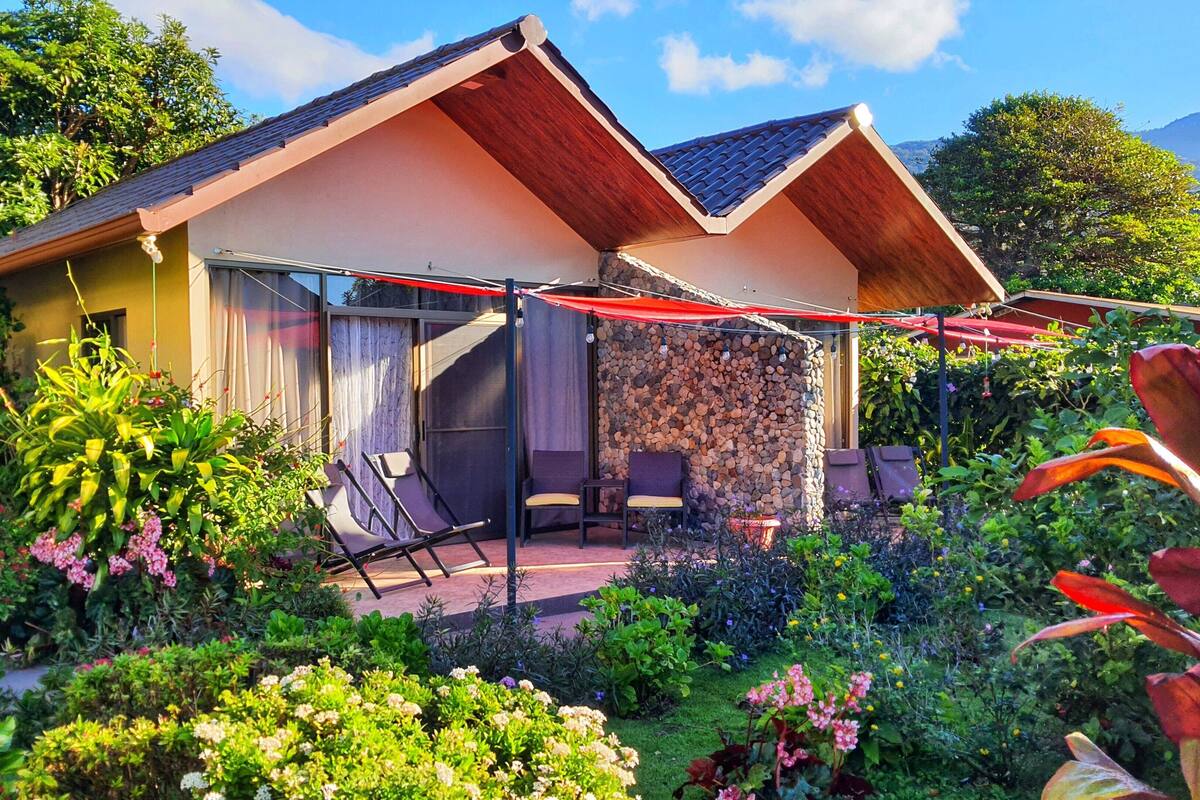 A house with a patio, outdoor seating, and a garden.