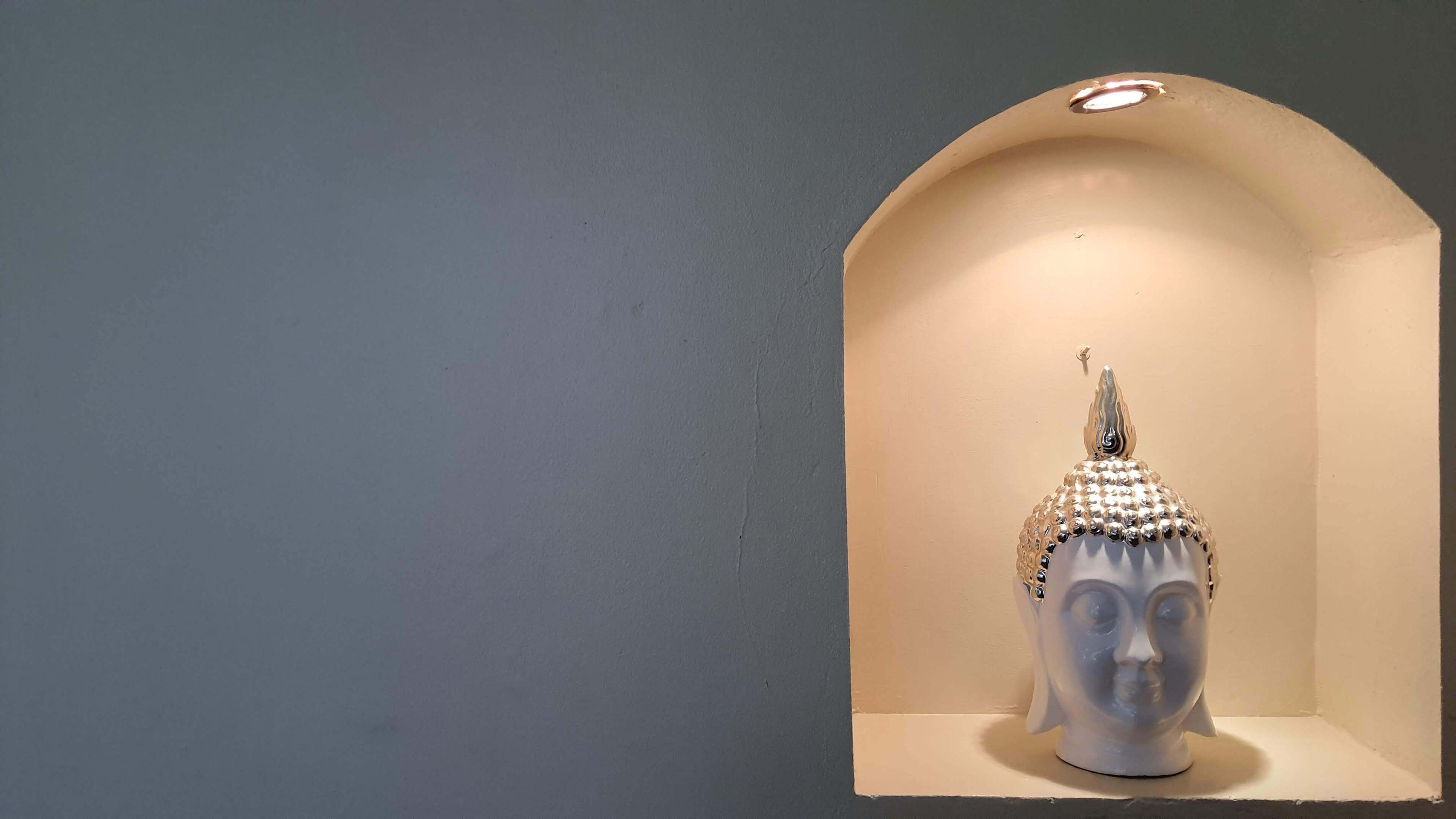 A sculpture in a niche with a light fixture above.